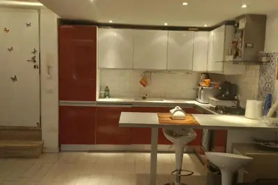 a kitchen with white cabinets and a table in it at Little Villa Well connected in Rome