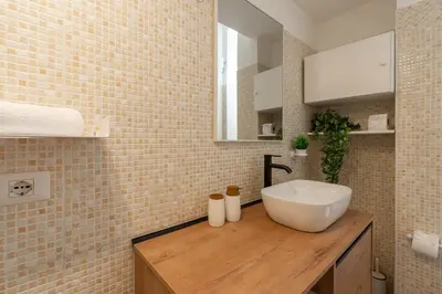 a bathroom with a white sink on a wooden counter at Typical & Cozy Apartment - Testaccio - Trastevere in Rome