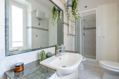 a bathroom with a sink and a toilet and a mirror at Maurice's Apt, hidden gem in Rome for food lovers in Rome