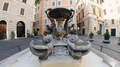 a statue of a fountain in the middle of a street at Celeste Suite Reginella in Rome