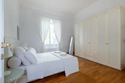 a white bedroom with a white bed and a window at Rome Vatican Home in Rome