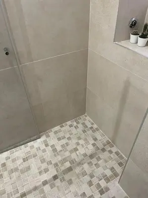 a shower with a glass door and a tiled floor at Rome Vatican Home in Rome