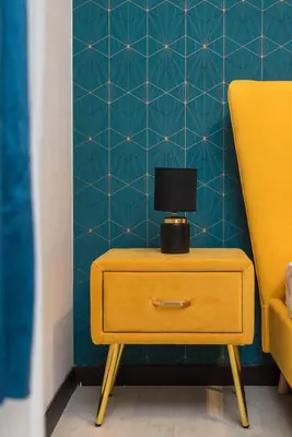 a side table with a lamp on it next to a yellow chair at Trastevere suites Luxury Garden Retreat in Rome