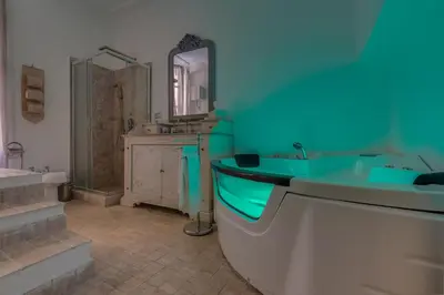 a bathroom with a tub and a sink and a mirror at Suite Experience Spanish Steps Apartment in Rome