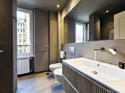 a bathroom with a sink and a toilet and a mirror at Angelico 70 - Amazing flat near the Vatican Museum in Rome