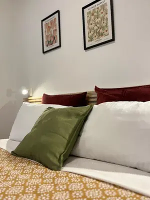 a green pillow sitting on top of a bed at Sampietrino Vatican Apartment in Rome