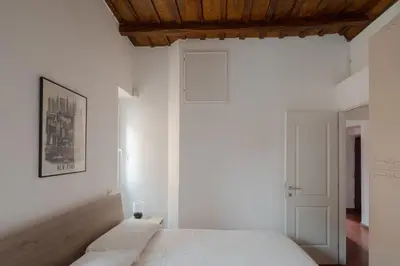a bedroom with a white bed and a wooden ceiling at Colosseum Apt in Rome