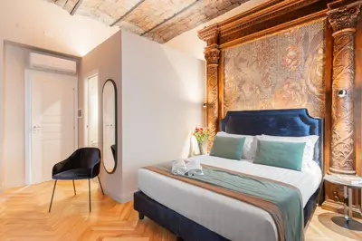 a bedroom with a large bed and a chair at H77 Apartments - Maison D'Art Collection in Rome