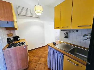 a kitchen with yellow cabinets and a sink and a stove at Vicolo di Monte del Gallo 24 - Vatican City in Rome