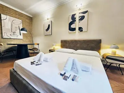 a bedroom with a large white bed and a table at Vicolo dell'Atleta 23 - Garden in Trastevere in Rome