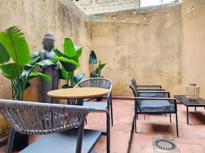 a patio with chairs and a table and a statue at Vicolo dell'Atleta 23 - Garden in Trastevere in Rome