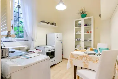 a kitchen with white appliances and a table at Central and Historic Rione near Colosseo in Rome