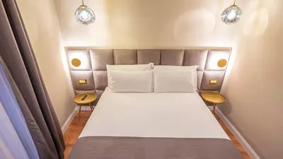 a bedroom with a bed with two tables and two lights at Navona Comfort Rooms in Rome