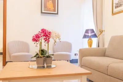 a living room with a table with flowers on it at St Peter's Comfort Lodge in Rome