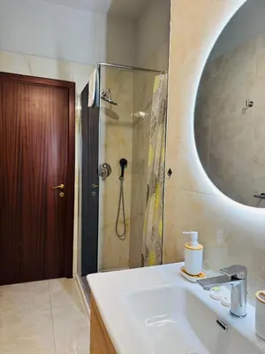 a bathroom with a sink and a shower with a mirror at Trastevere Tales in Rome