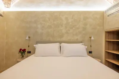 a bedroom with a white bed with two pillows at Trastevere Urbes Collection in Rome