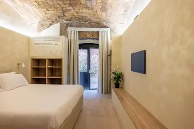 a bedroom with a bed and a tv on a wall at Trastevere Urbes Collection in Rome