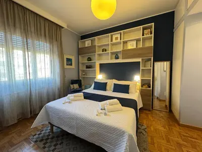 a bedroom with two beds and a large window at Room 55 Testaccio in Rome