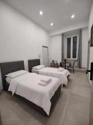 a room with three beds with white sheets on them at Lifestyle 168 Guest House in Rome