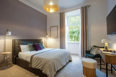 a bedroom with a bed and a desk and a window at BruSilva al Colosseo in Rome