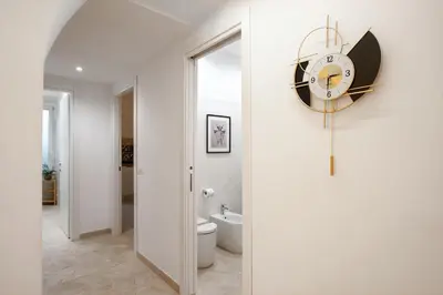 a bathroom with a clock on the wall and a toilet at BruSilva al Colosseo in Rome