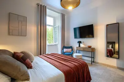 a bedroom with a bed and a tv and a chair at BruSilva al Colosseo in Rome