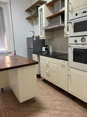 a kitchen with white appliances and a wooden floor at Planny Apartment - Vaticano in Rome