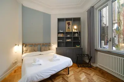 a bedroom with a white bed and a book shelf at Castel Sant'Angelo by BuddyRent in Rome