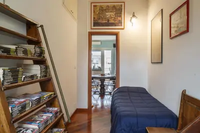 a room with a book shelf with dvds at Olimpico Apartment in Rome