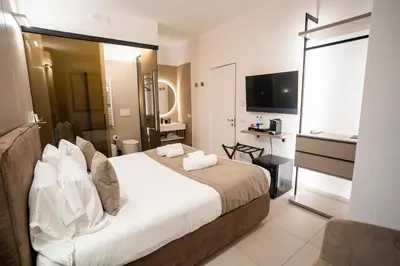 a hotel room with a bed and a television at Cicerone's Luxury Suites in Rome