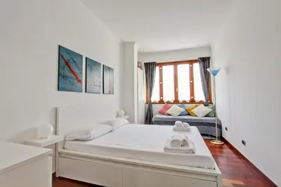 a white bedroom with a bed and a couch at Cherry in Rome in Rome