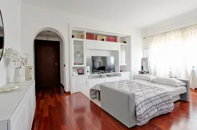 a white bedroom with a bed and a television at Cherry in Rome in Rome