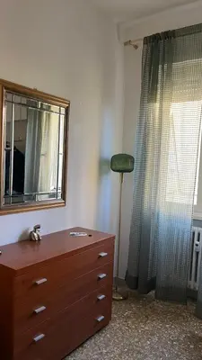 a bedroom with a dresser and a mirror and a lamp at Casa Fiore in Rome
