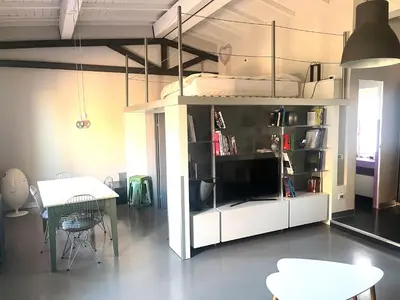 a living room with a table and a white book shelf at Stylish duplex with terrace Rome in Rome
