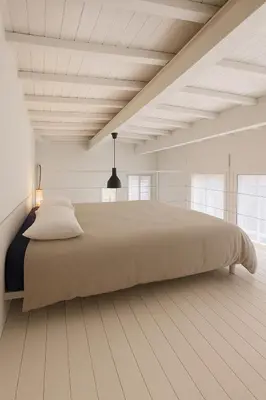 a bedroom with a large bed in a white room at Stylish duplex with terrace Rome in Rome