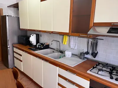 a kitchen with white cabinets and a sink at ALGA Roma in Rome