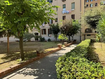 a sidewalk in front of a building with a tree at Casa Gigi al Vaticano in Rome