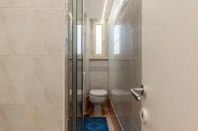 a bathroom with a toilet and a window at GuestHost - Lungotevere central and bright apartment in Rome