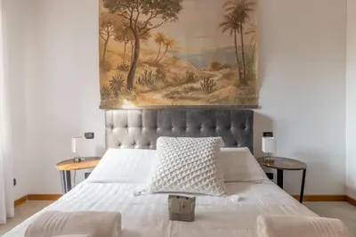 a bedroom with a bed with a painting on the wall at Quattro Fontane 2P - B&D Apartments in Rome
