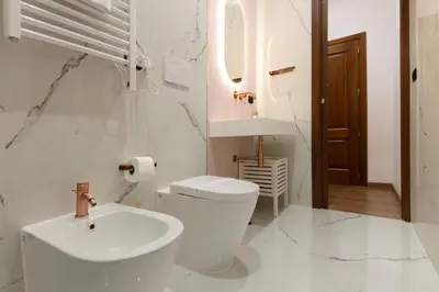a white bathroom with a toilet and a sink at Vatican Design Suites in Rome
