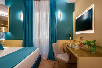a bedroom with a bed and a desk with a computer at VentiSettembre Private Suites in Rome
