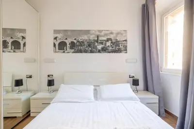 a white bedroom with a bed and two night stands at Quattro Fontane 4P - B&D Apts in Rome