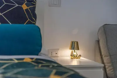 a lamp on a table next to a bed at Trastevere - Monteverde Apartment in Rome