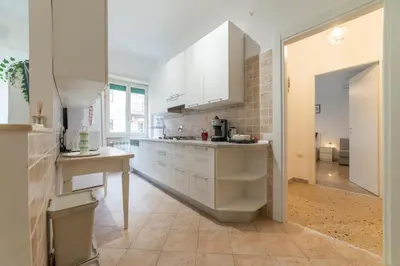 a kitchen with white cabinets and a tile floor at Trastevere - Monteverde Apartment in Rome