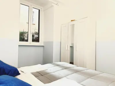 a white bedroom with a bed and a window at Scala Santa Home in Rome
