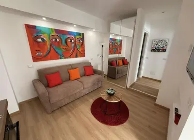 a living room with a couch and a colorful painting at Colosseo Licia Apartment in Rome