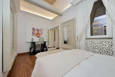 a bedroom with two beds and a mirror at Vicolo Savelli Luxury Suites in Rome
