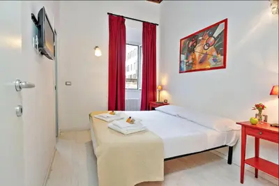 a bedroom with a bed with a table and a window at Campo de fiori charm apartment in Rome