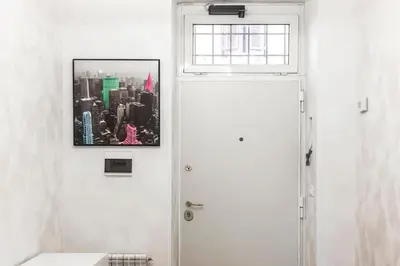 a bathroom with a white door and a picture on the wall at colosseo view apartment in Rome
