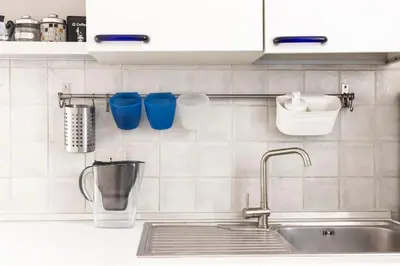 a kitchen sink with blue cups on the wall at colosseo view apartment in Rome